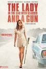 DAME DANS L'AUTO AVEC DES LUNETTES ET UN FUSIL